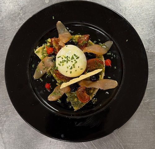 Burrata, pesto et tomates confites sur assiette noire