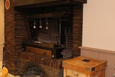 La grande cheminée de la salle et sa grille à rôtir