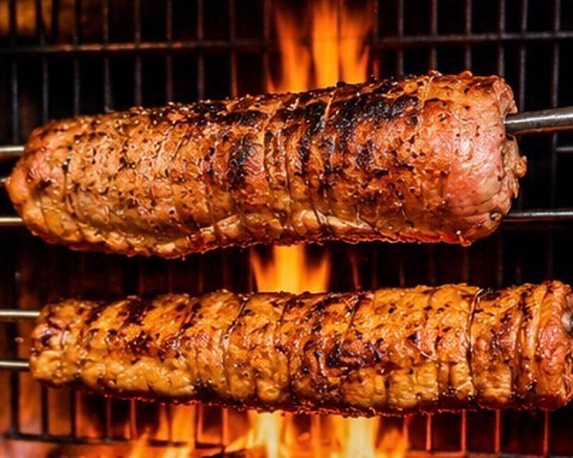 Deux pièces de viande à la broche au-dessus du feu de bois