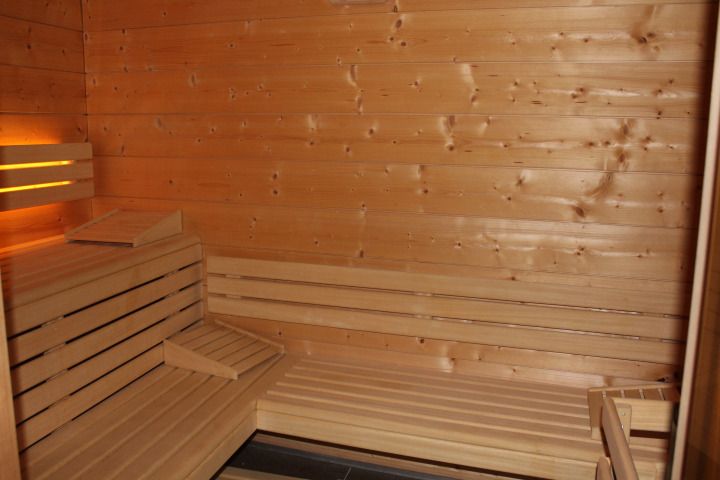 Banquettes du sauna en épicéa, lumière ambrée